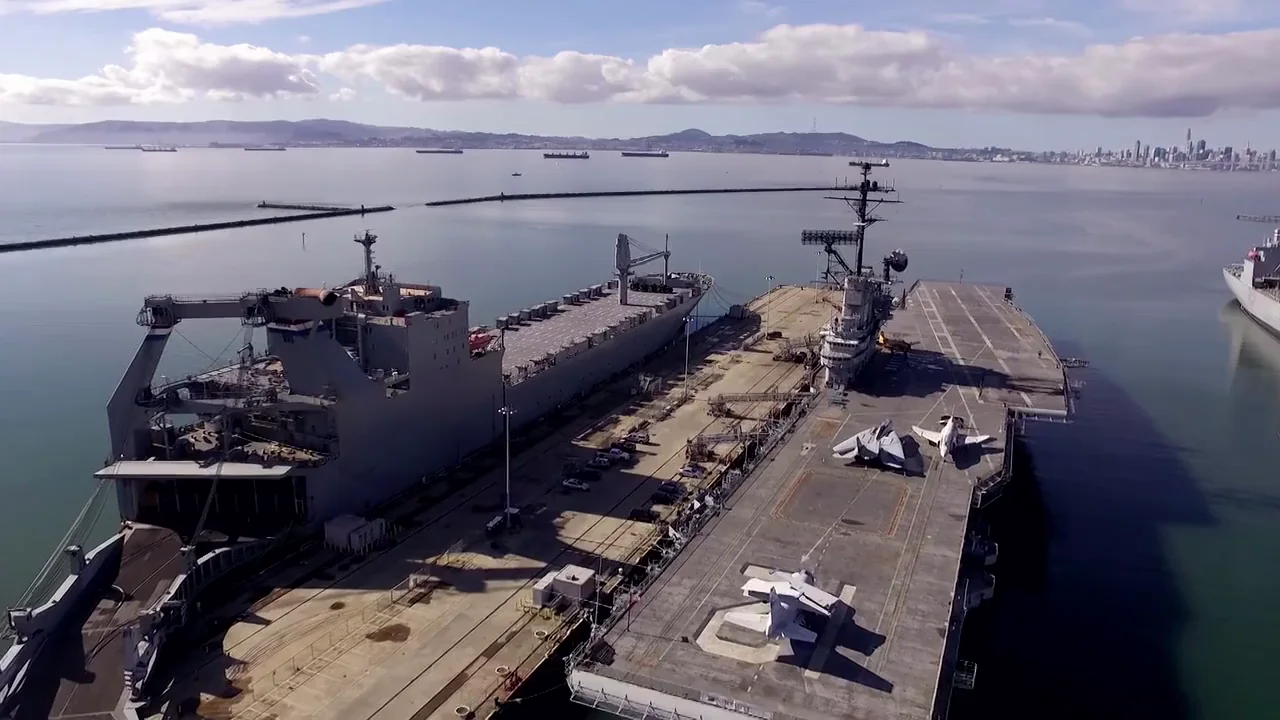 Aircraft carrier and support vessel at a harbor